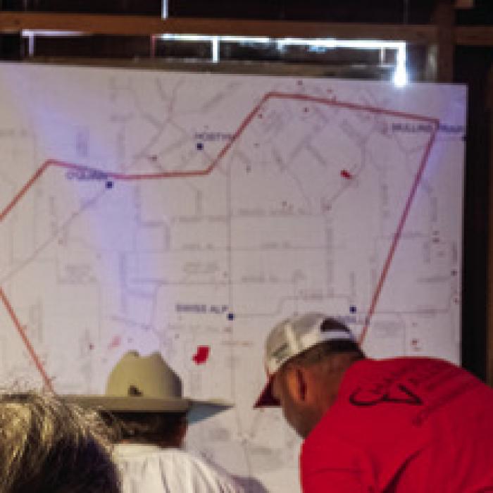 Landowners at the meeting examine a large map of the area Apex is interested in leasing for the wind power project. The area is centered around Swiss Alp.