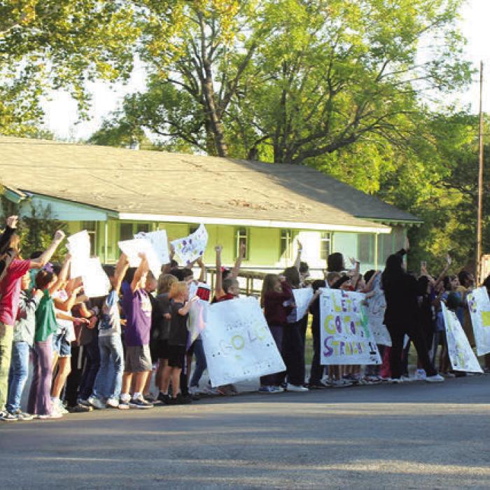 La Grange elementary students line Milam Street with signs as the charter buses carried the band members to the Alamodome for the state marching contest Wednesday. Photo by Jeff Wick