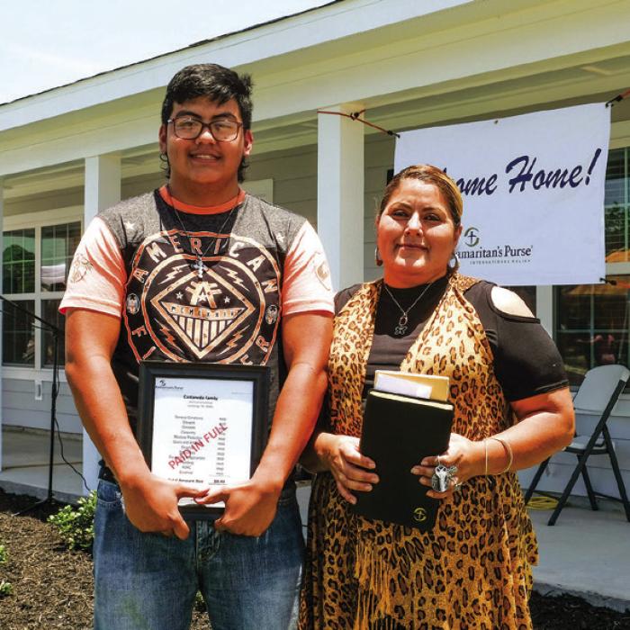 Jose and Francisca Castaneda hold a bible and a bill stamped “paid in full” in front of their new home in Hope Hill in this June 2020 photo. They had lived in La Grange for 10 years before they lost their home in Hurricane Harvey. They were one of the first families to get a home in Hope Hill.