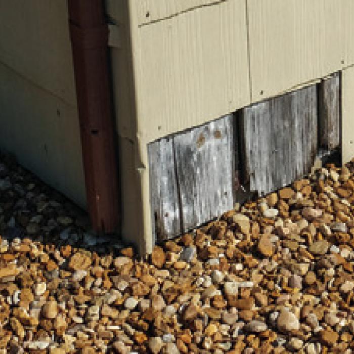 A piece of siding is missing from the wall near the entrance to the VFW Hall – an unsightly though relatively minor issue compared to the foundation and roof problems.
