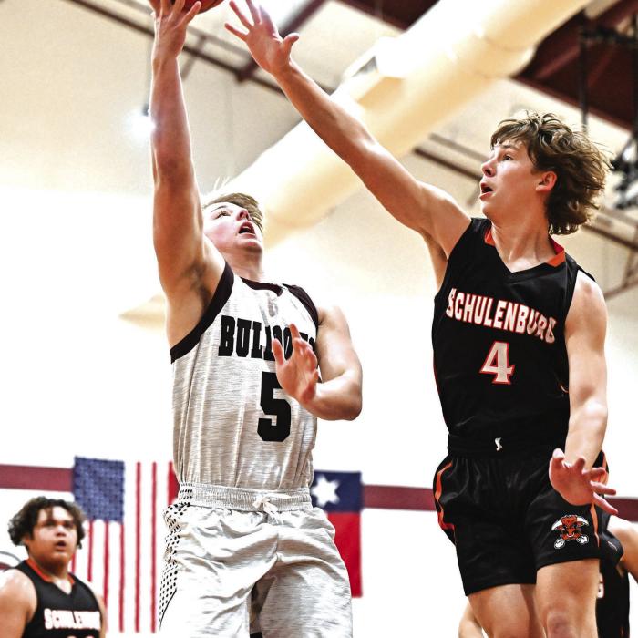 Flatonia’s Dayton Cliffe goes up for two for the Bulldogs against the defense of Schulenburg’s Aaron Janacek Friday. Photo by Stephanie Steinhauser
