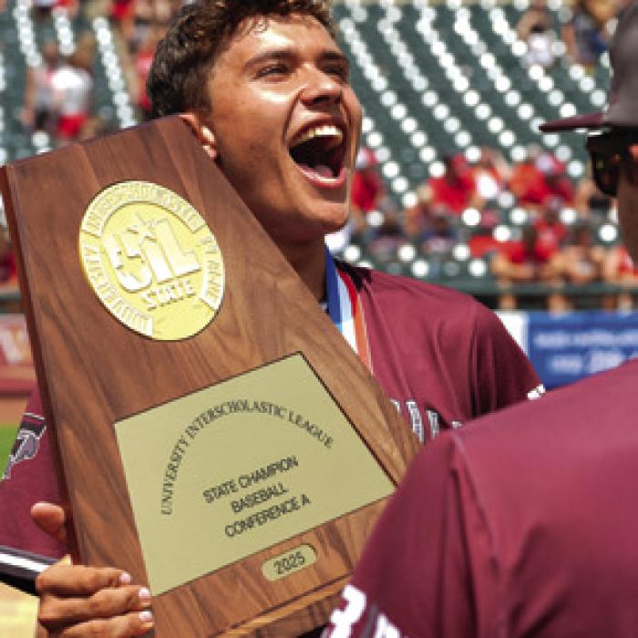 Luke Beseda lets out a yell as he holds the state title trophy Saturday. Photo by Scott Coleman