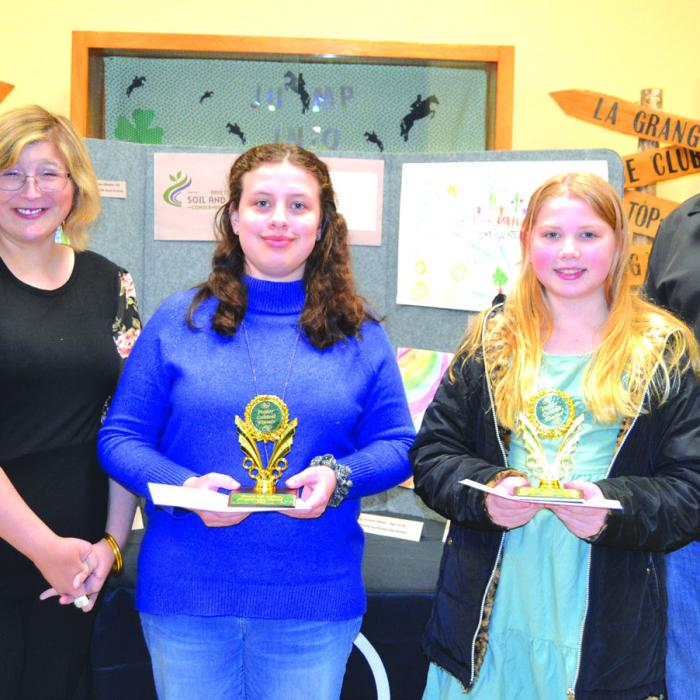 Poster Contest: (Division 2-Grades 3-6) - Brynlee Berger (St. Rose of Lima, Schulenburg), Tabitha Smith (Sacred Heart School); presenters: Chris Kaspar of Round Top State Bank and Jessica Montez of Fayette Electric Cooperative.