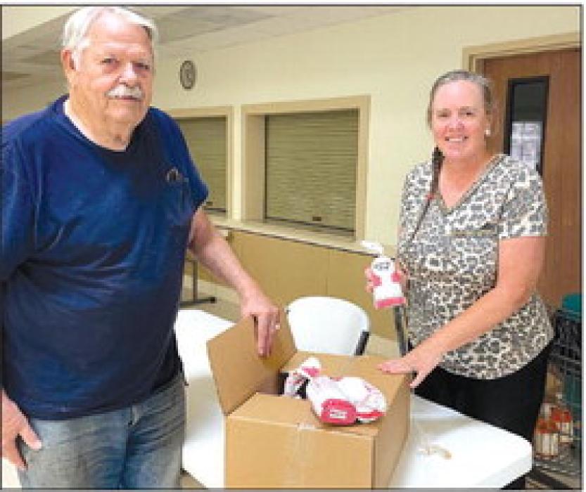 The Columbus Food Bank received a donation from CattleWomen. Pictured is Susie Shank, NVCW, and Tom Fleming, Columbus Food Bank.