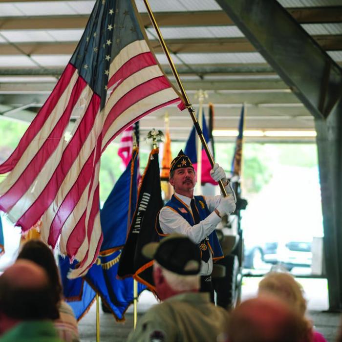 American Legion Post 143 First Vice Commander Ed Selmer waved a “Ragged Old Flag” while the Johnny Cash song by that name played over the PA system.