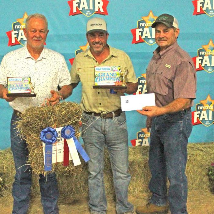 Dennis Brower won Grand Champion at The Fayette County Fair Hay Show Thursday. He is shown here, left, with his hay. Center is Matt Arthur of Bumper Crop Texas, who bought the hay for $1,900. Right is Mark Vecera representing Farmers Coop in Schulenburg, which donated 1,000 pounds of fertilizer to the winner. Vecera is also the Chairman of The Schulenburg Young Farmers, which sponsored the hay show. Photos by Jeff Wick