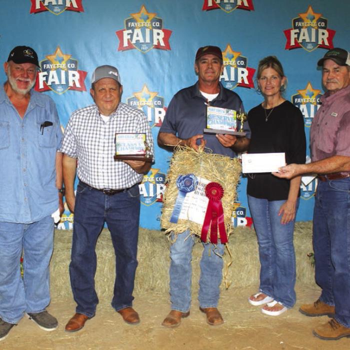 Mark Stang won Reserve Champ at The Fayette County Fair Hay Show Thursday. He is shown center holding the hay, which sold for $1,800. Left to right: Buyers Ed Moeller of Moeller’s Custom Lawn Mowing, Rodney Kalich, Fayette Savings Bank; Mark Stang, Susan Wick of Tex Propane and Mark Vecera, representing Bumper Crop Texas.