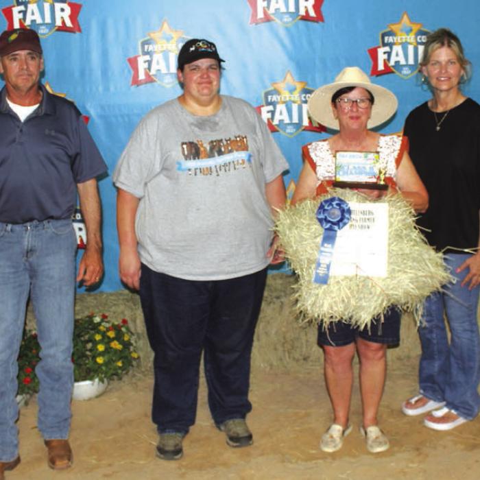 Derrl Ohnheiser won first place in Class 2 at The Fayette County Fair Hay Show Thursday. Dina Ohnheiser is shown holding the hay, which sold for $950. Left to right: Mark Stang, Stang Cattle Company, Chelsea Moeller, Rockin’ Circle C Show Goats, Dina Ohnheiser, and Susan Wick of Tex Propane.