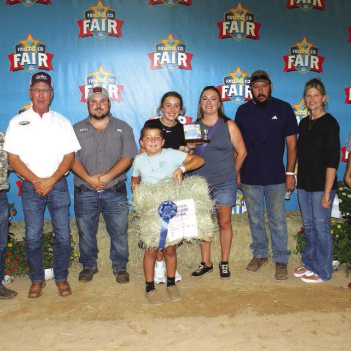 Clay Hajovsky won First Place in Class 1 at The Fayette County Fair Hay Show Thursday. Frank Hajovksy is shown center holding the hay, which sold for $850. Left to right: Buyers Kent Ohnheiser of M-G, David Kleiber and Ryan Kleiber of Kleiber Tractor, Frank, Lillie and Cassie Hajovsky, Daniel Wick of Wick Water Well Service, Susan Wick of Tex Propane and Rodney Kalich of Fayette Savings.