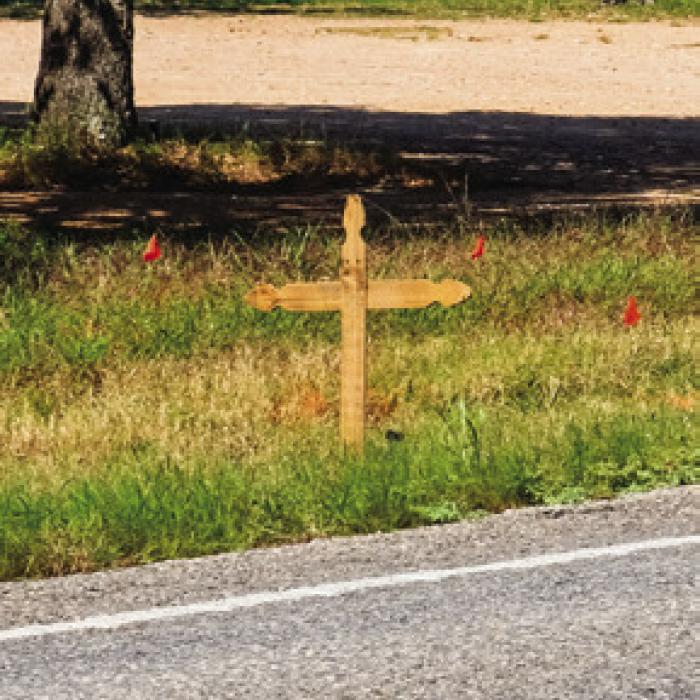 A wooden cross now marks the spot where Bradley Votaw, 43 of La Grange, died in a motorcycle crash near Post Oak Inn on FM 155 last Tuesday. Photo by Andy Behlen