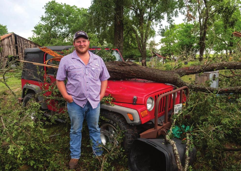 Above, Chris Filip stands in front of the tree that fell on a Jeep at his place in the Ammannsville area Wednesday morning. Photos by Andy Behlen