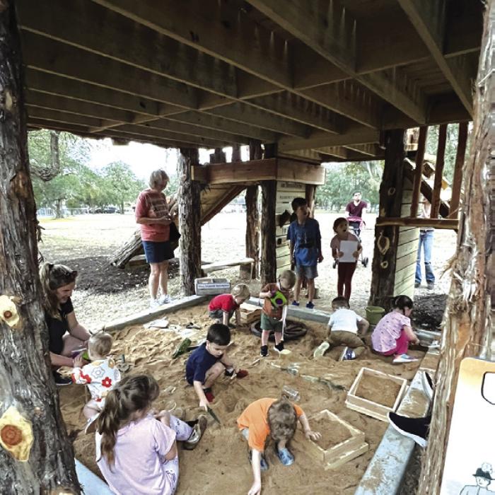 Young visitors learn about the tools used to find artifacts in the archeological dig pit.