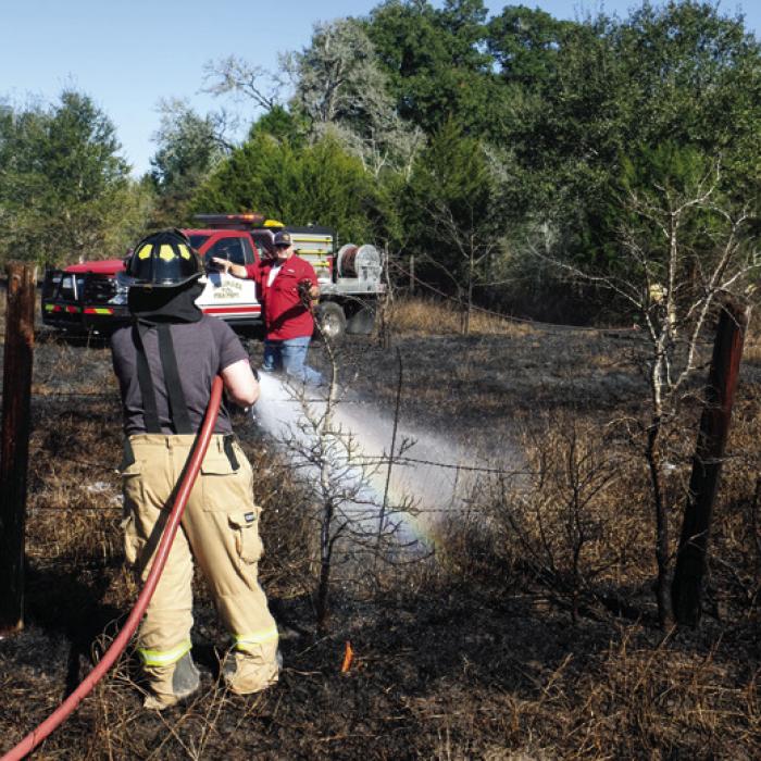 Ellinger and La Grange Volunteer Fire Departments battle a grass fire near the intersection of SH 71 and Kitchen Ln. Photo by Andy Behlen