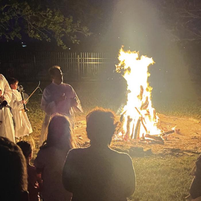 Many Catholic Easter Vigil Masses the night before Easter begin with a ceremony around a fire like this one outside Holy Rosary Church in Hostyn Saturday. The fire symbolizes the “light of Christ, rising in glory,” scattering the “darkness of our hearts and minds.”