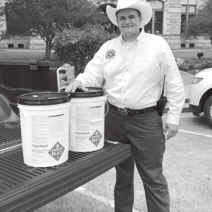 Fayette County Chief of Emergency Management and Homeland Security Craig Moreau with the 15 gallons of hand sanitizer donated by ExxonMobil.