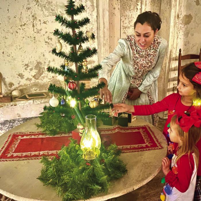 Jennifer Townzen, Lead Educator at Kreische Brewery and Monument Hill State Historic Sites, shows off a traditional Christmas Tree inside the Kreische House to visitors as a previous Trail of Lights evening.