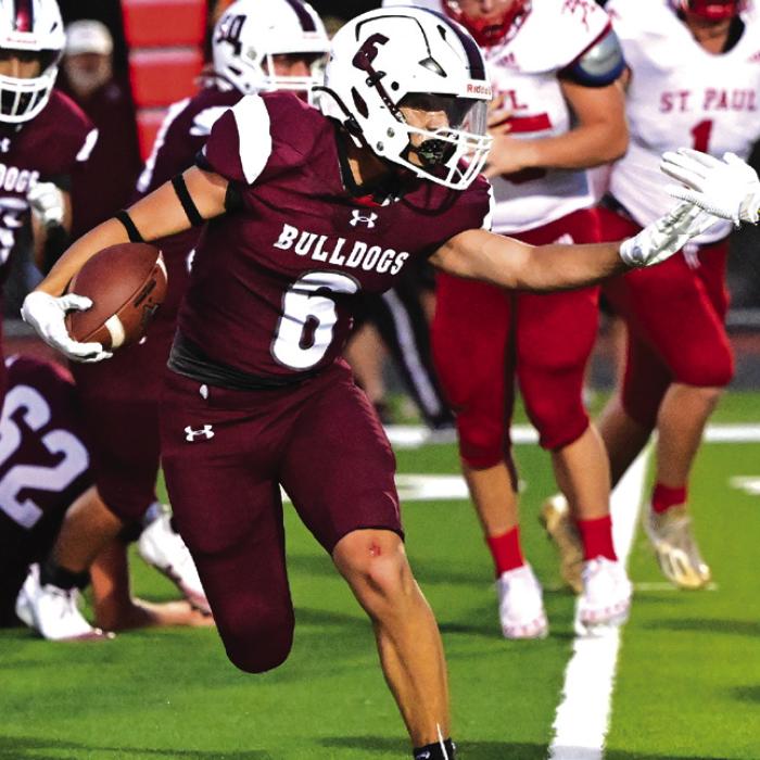 Caysen Perez makes his way around a stout St. Paul defense to bring the Bulldogs up to 27 against the Cardinals. Photo by Stephanie Steinhauser