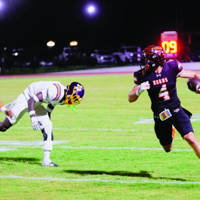 Jayse Janda strides downfield with a pair of Wildcats in pursuit. Photo by Andy Behlen