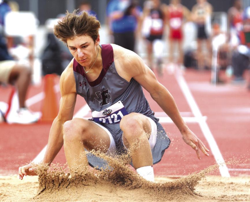 Fayetteville’s Jack Schley lands in the sand pit on his way to a fifth place finish in the 1A triple jump.