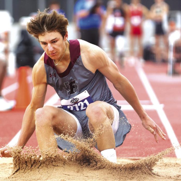 Fayetteville’s Jack Schley lands in the sand pit on his way to a fifth place finish in the 1A triple jump.