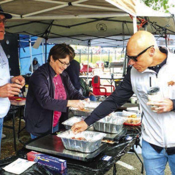 Schulenburg businessman Chip Bubela samples some sausage made by the Hackberry Wurst cooking team.