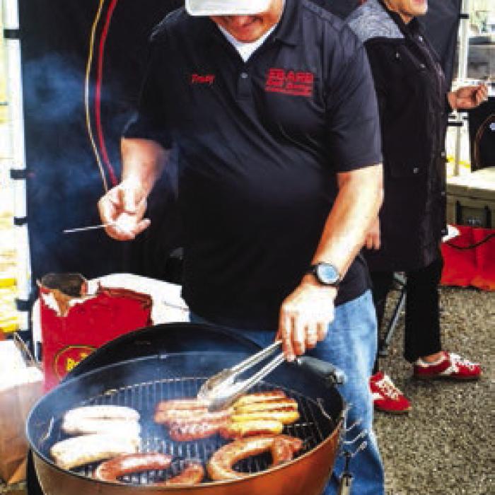 Tracy Ebarb of Ebarb Craft Sausage grills some of his company’s famous links at their booth during the Sausagefest