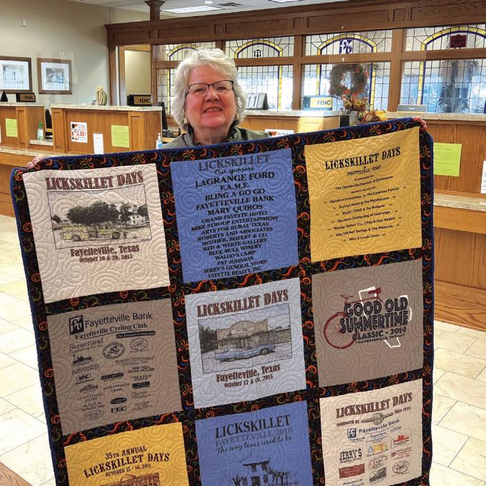 Fayetteville artist, Pat Johnson with the Lickskillet T-shirt quilt. She has been responsible for the art used in the t-shirt designs for over 40 years.
