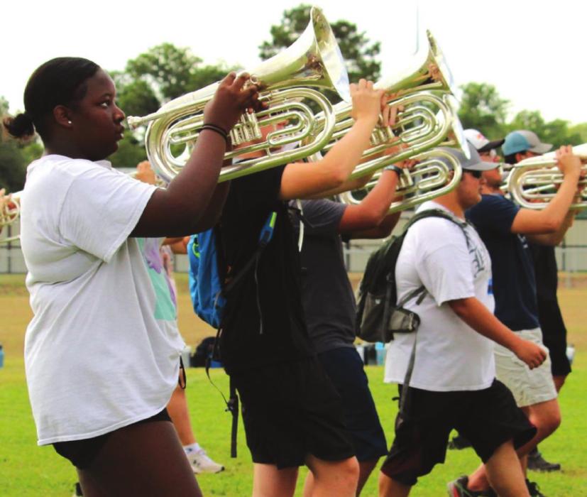 The baritone section holds their horns up as they march during outside rehearsals. Photos by MaKenzie Givan