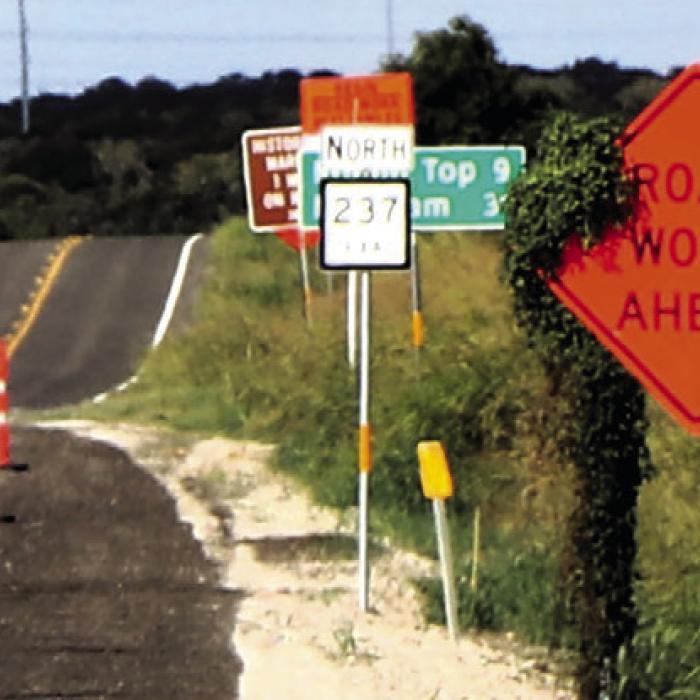 The roadwork on SH 237/159 northeast of La Grange seems like it will never end. Pretty soon, the Highway Department will need to cut these vines that are starting to overgrow their construction signs. Photo by Gary E. McKee