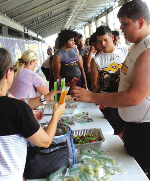 Parents handed out popsicles, watermelon and grapes to the players under the stands during a break Monday afternoon at the first day of high school football practice. Photo by Jeff Wick
