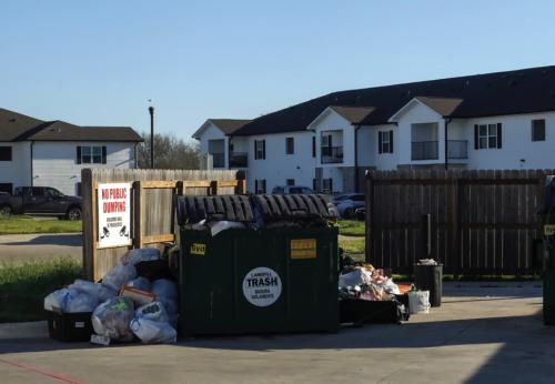 Garbage keeps piling up at the La Grange Springs Apartments. Some of it has blown across the street and into neighboring property. Photo by Andy Behlen