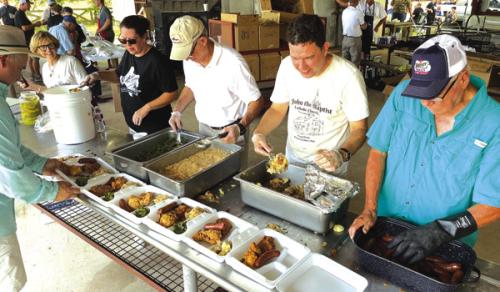 Church members load up the plates at last year’s Ammannsville church picnic, always on Fathers’ Day.