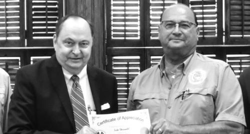 County Judge Dan Mueller presents Luke Sternadel last week with a certificate honoring his retirement. Mueller has chosen Luke’s son Clint to fill out the rest of his term as commissioner.