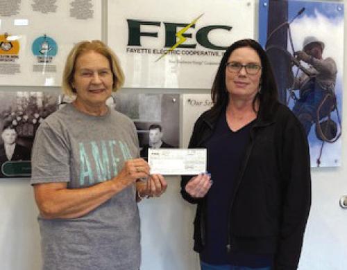 Tracy Denton, Director of Marketing at FEC, presents to Linda Oltmann, AMEN Board Member a donation of $250 for purchase of reusable bags.