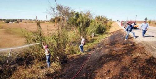 Schulenburg volunteer firefighters put out a grass fire on the side of US 77 near Swiss Alp Tuesday. Fire Chief Jeff Proske said the fire may have been caused by a blown out tire from a passing vehicle. Photo by Andy Behlen