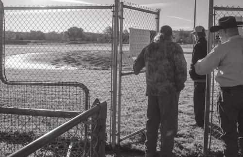 La Grange Little League officials Byron Gross and Eric Tillery, along with La Grange Police Chief David Gilbreath, inspect the damage discovered at one of the fields in White Rock Park. They believe some local youths may have raced a couple of horses around the bases. Photo by Andy Behlen