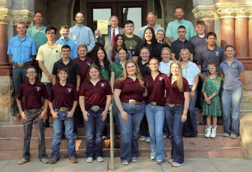 Fayette County 4-H students (with the county Leadership Council members in front) stand outside the courthouse Wednesday morning after they gave a report on their activities to the Commissioners Court and County Judge Dan Mueller (who is holding a proclamation he signed designating Oct. 4-10 as National 4-H Week in Fayette County.) Photo by Jeff Wick