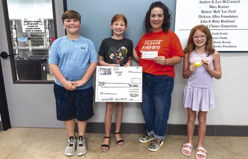 Local students recently presented a $725 donation to the Gardenia E. Janssen Animal Shelter in La Grange after raising the money through a community lemonade stand. Pictured, from left, are Colby Walker, a fifth grader; Stevi Kadlecek, a fourth grader; Gardenia E. Janssen Animal Shelter Executive Director Tiffany Reid; and Landri Kadlecek, a third grader. Not pictured is Tucker Ming, a fourth grader, who also helped at the lemonade stand.