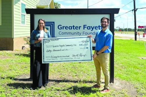 Susannah Mikulin, CEO of the Greater Fayette Community Foundation, and Caleb Parks, Main Street Manager for the City of La Grange, celebrate the check presentation together.