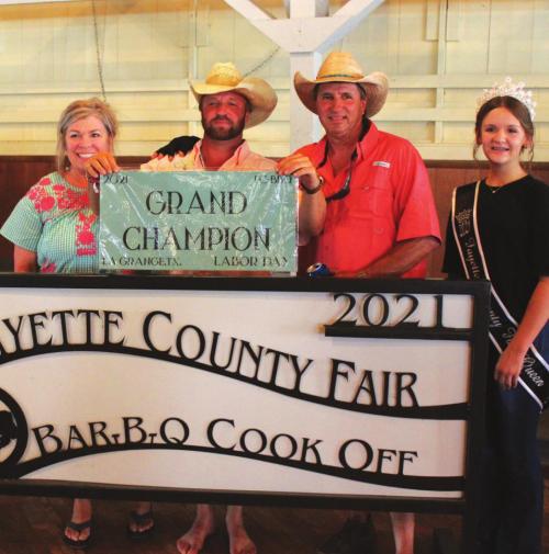 The Grand Champion of this year’s Fayette County Fair Bar-B-Q Cook-Off was the “All Sauced Up” team of La Grange which included Bubba Schneider, Brandon Schneider and Sheri Schneider. Also shown is Fayette County Fair Queen Charlee Wessels.