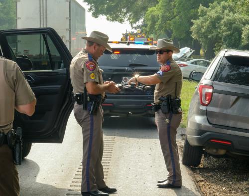 Crash investigators with the Texas Department of Public Safety prepare to launch a drone to capture overhead images of the crash scene. The driver of the white Hyundai car in the background died in the crash