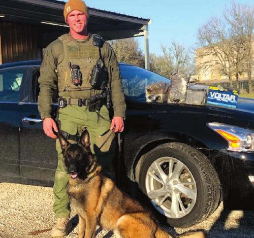 Sgt. Randy Thumann and K-9 partner Kolt with the 15 lbs. of heroin in a car battery found inside the car.