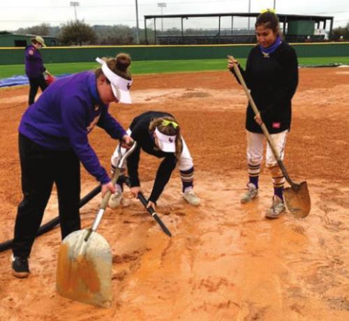 La Grange players work on the wet softball field Thursday.