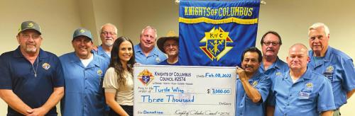 Pictured from left are David Shimek, Hector Cervantes, Garry Schellberg, Destiny Psencik (Turtle Wing Foundation Executive Director), Charles Youngblood, Jim Kothmann; other side of the flag (right side), front row: Philip Rocha, Ralph Dunk, Marcus Recek and Pat Lyons.