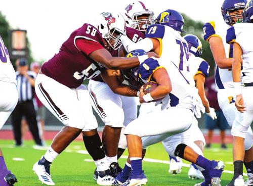 Devon Walles (58) and Kobe Burton (60) stop Runge from moving the ball down the field in Friday night’s 61-0 shutout. Photo by Stephanie Steinhauser