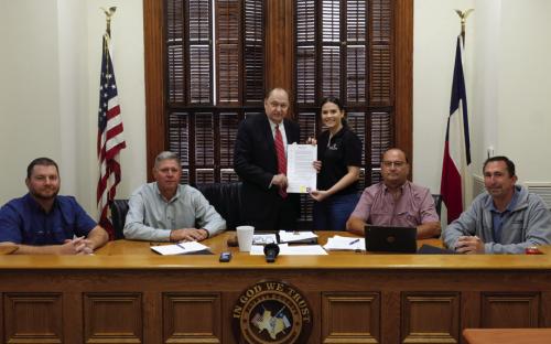 Pictured are (from left) Pct. 4 Commissioner Drew Brossmann, Pct. 3 Commissioner Harvey Berckenhoff, County Judge Dan Mueller, Destiny Siptak, Pct. 2 Commissioner Luke Sternadel, and Pct. 1 Commissioner Jason McBroom. Photo by Andy Behlen