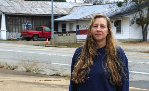 Susan Williams stands on the curb across Travis St. from Pops Star Bar on Sunday, Dec. 21. Photo by Andy Behlen