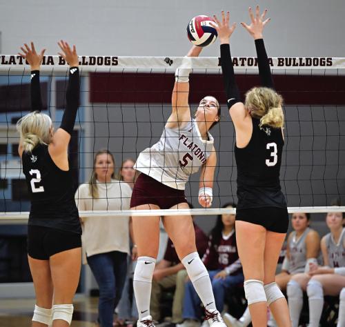 Flatonia’s Abbie Uzzell spikes a ball between Fayetteville players Aubree Graeter, left, and Scotti Beseda, right. Photo by Stephanie Steinhauser