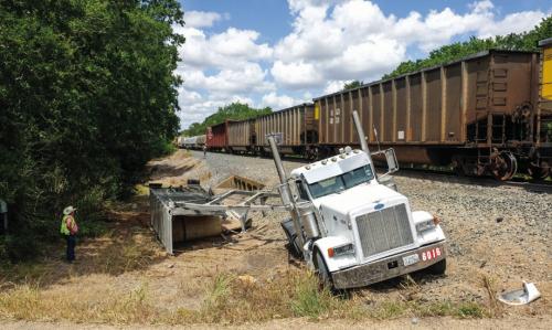 A Union Pacific train smashed through an 18-wheeler trailer hauling a load of gravel on Huelsebusch Rd. Tuesday around noon. The truck-tractor and part of the trailer ended up on the south side of the tracks (pictured left) while the back half of the trailer came to rest on the north side of the tracks (right). Photos by Andy Behlen
