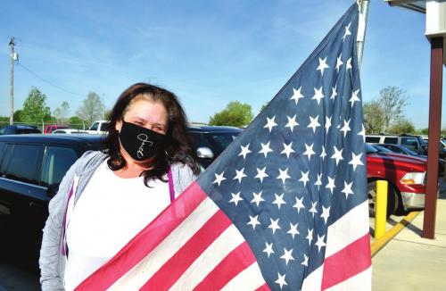 Sherry Faith saw that there was an American flag for sale at Second Chance Emporium in La Grange, so she was in line 90 minutes before the store opened at 9 a.m. Friday. She got her flag, which she will add to an Independence Day display on her front porch on Baumgarten Street in Schulenburg. Photo by Bill Bishop